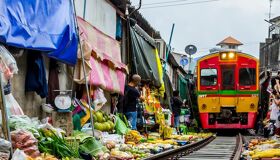Iconic train tracks through Mae Klong Market for a Mae Klong Tours banner with Legend Travel Group.